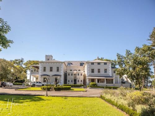 a large white house with a parking lot at Kearsney Manor in KwaDukuza