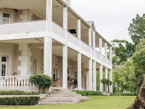 a white house with columns and grass at Kearsney Manor in KwaDukuza