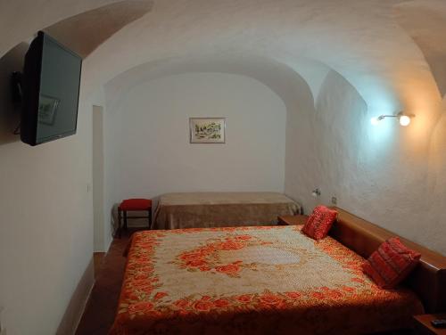 a bedroom with a bed and a tv in a room at Casa Arancia in Isolabona