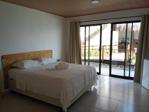 a bedroom with a bed and a sliding glass door at Lighthouse Pipa in Tibau do Sul
