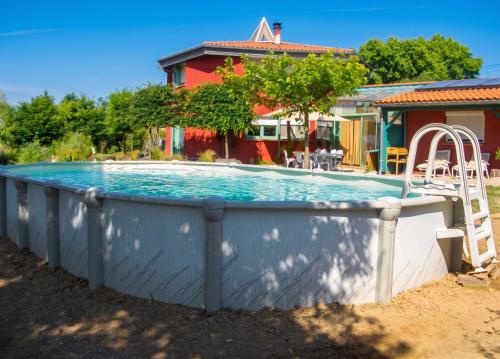 a swimming pool with a slide in front of a house at Maison cosy avec piscine privée à Estibeaux 38 m² in Estibeaux