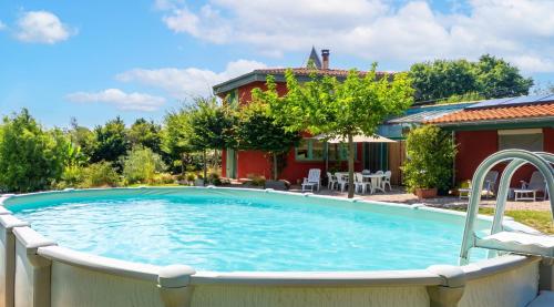 a swimming pool in front of a house at Maison cosy avec piscine privée à Estibeaux 38 m² in Estibeaux