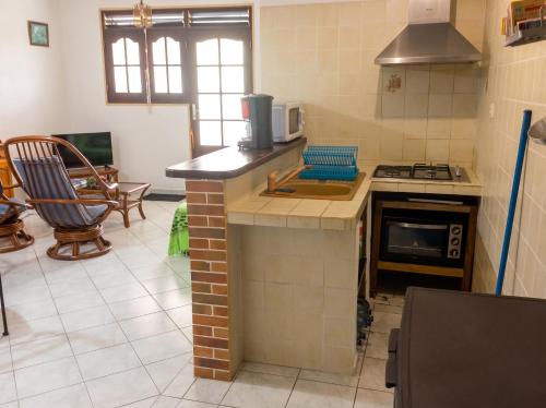 a kitchen with a stove and a counter top at Appartement spacieux à Petit Canal - 65 m² - Vue sur jardin in Petit-Canal