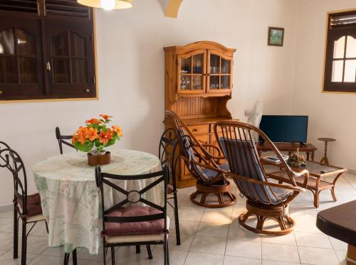 a dining room with a table and chairs and a stove at Appartement spacieux à Petit Canal - 65 m² - Vue sur jardin in Petit-Canal