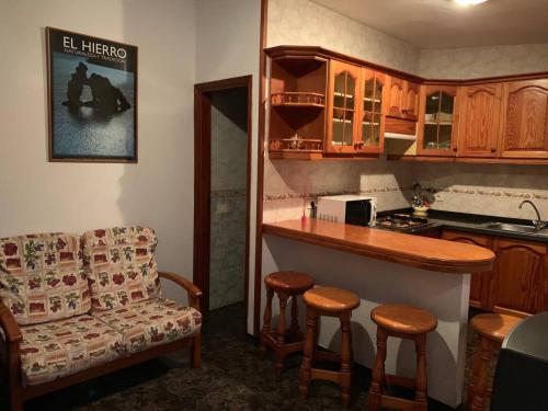 a kitchen with a counter and a bar with stools at Cozy apartment with sea view in Frontera in Frontera