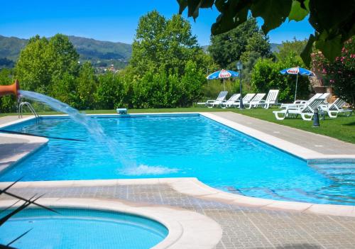 a swimming pool with a water fountain at Charming villa with mountain view in Pedraça, pool in Pedraça