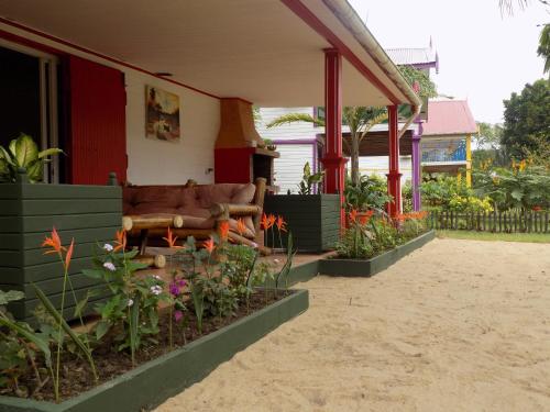 a couch sitting on the porch of a house at Charming house with sea view in Foulpointe + Enclosed garden. in Foulpointe