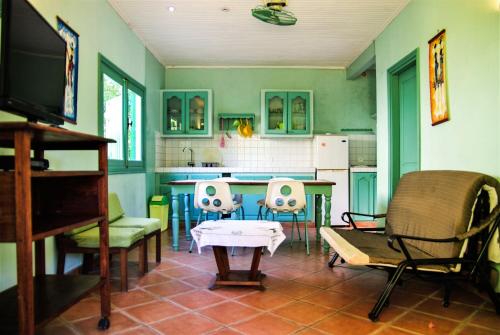 a kitchen with chairs and a table and a tv at Charming house with sea view in Foulpointe + Enclosed garden. in Foulpointe