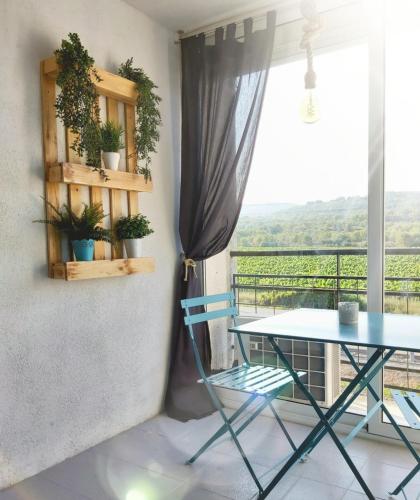 a table and a chair in front of a window at Charming apartment with mountain view in Francàs - 45m² in Comarruga
