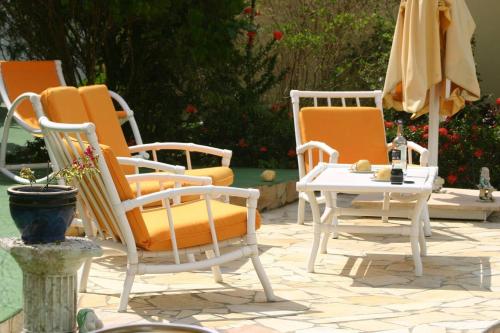a group of chairs and a table on a patio at Villa élégante à Sainte-Anne avec piscine privée ouverte toute l'année in Sainte-Anne