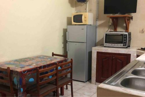 a small kitchen with a microwave and a refrigerator at Appartement Moderne à Capesterre de Marie Galante avec Balcon in Vidon