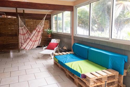 a screened in porch with a couch and a hammock at Maison charmante vue sur mer à La Trinité, 2 chambres. in La Trinité