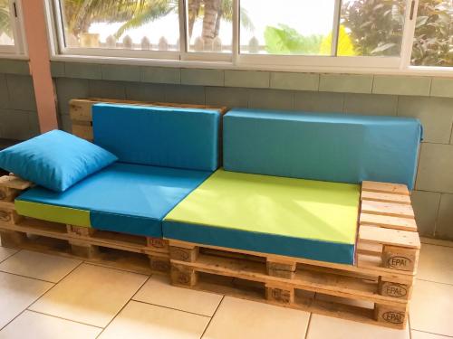 a bench made out of pallet wood with a blue and green couch at Maison charmante vue sur mer à La Trinité, 2 chambres. in La Trinité