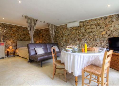 a living room with a table and a couch at Studio accueillant à Moltifao 30 m² avec terrasse et jardin in Moltifao