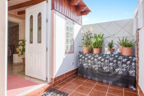 a porch with potted plants and a white door at Charming House in Costa Calma with Mountain View and Terrace in Costa Calma