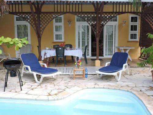 a patio with a table and chairs and a swimming pool at Charming villa in Blue Bay with private pool in Blue Bay
