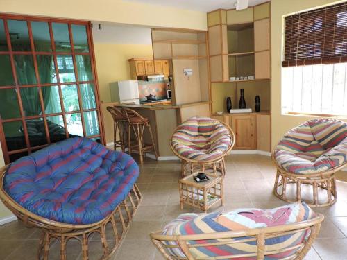 a living room with three chairs and a kitchen at Charming villa in Blue Bay with private pool in Blue Bay