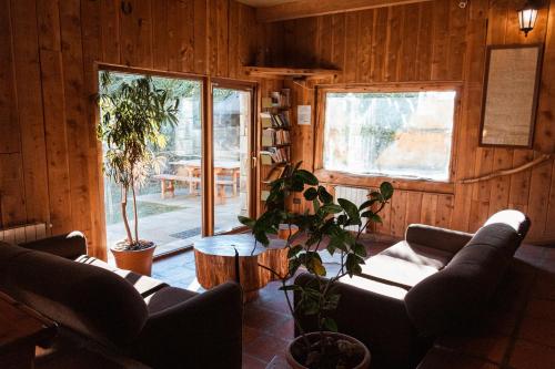 a living room with couches and a table and windows at Periko´s Youth Hostel in San Carlos de Bariloche