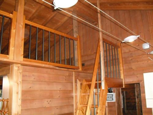 a staircase in a cabin with wood walls at Comfortable Chalet in Giarola with Mountain View in Busana