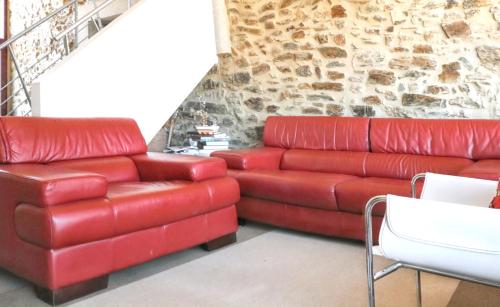 a living room with a red couch and a chair at Cozy House in Seia with Fireplace in Faia