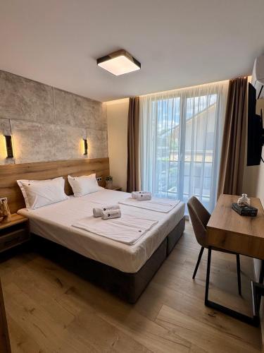 a bedroom with a large bed and a large window at Хотел Камъните in Burgas