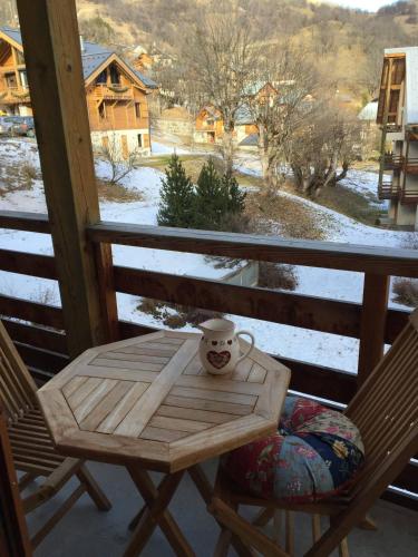 a table on a porch with a coffee cup on it at Studio charmant à Valloire - 21m² - Vue sur montagne in Valloire