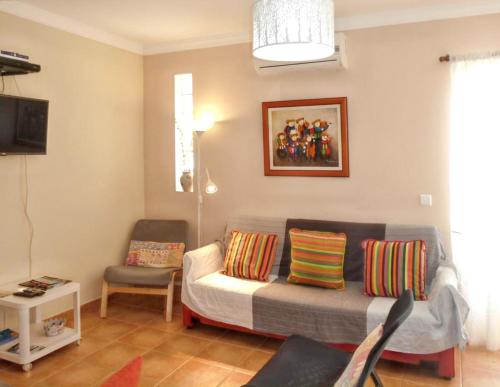 a living room with a couch and a chair at Charming house in Vila Nova de Cacela with garden in Vila Nova De Cacela