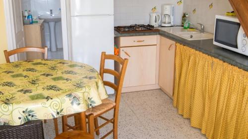 a small kitchen with a table and a microwave at Maison charmante à Montblanc avec terrasse in Montblanc