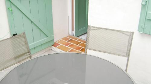 a glass table and chairs in front of a door at Maison charmante à Montblanc avec terrasse in Montblanc