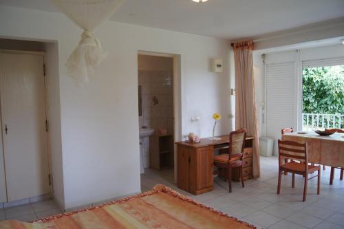 a kitchen and dining room with a table and chairs at Studio cosy au Moule 30 m² avec jardin privé in Le Moule