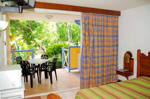 a bedroom with a bed and a table and chairs at Studio chaleureux à Sainte-Anne - 29m² avec jardin. in Sainte-Anne