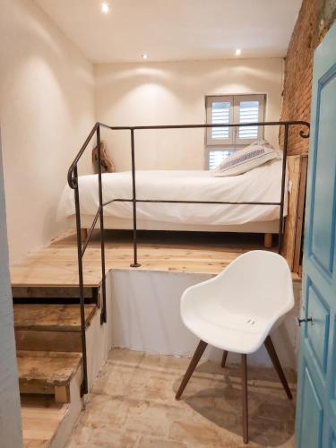 a room with two bunk beds and a white chair at Appartement spacieux à Algajola in Algajola