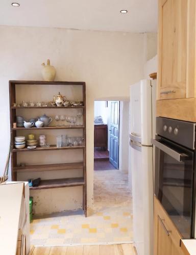 a kitchen with an open pantry with dishes at Appartement spacieux à Algajola in Algajola