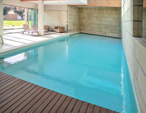 a swimming pool with blue water in a house at Spacious villa in Santo Tirso with private pool 850 m² and jacuzzi in Santo Tirso