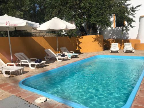 a large swimming pool with chairs and umbrellas at Elegant Villa in El Saucejo with Private Pool in Saucejo