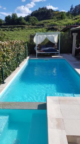 a blue swimming pool with a gazebo at Charming villa in Cividade, 150 m² with private pool in Cividade