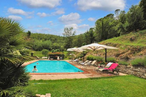 a swimming pool with a person in a yard at Spacious Apartment in Lisciano Niccone with Mountain View in Mercatale