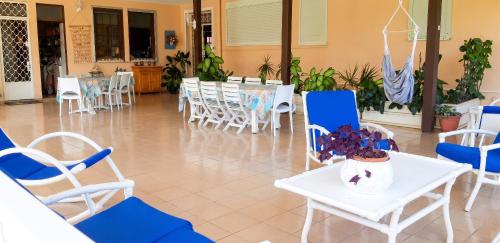 a room with chairs and tables and a table and chairs at Studio accueillant à Baie Mahault - 20 m² avec piscine privée in Baie-Mahault