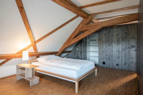 a bedroom with a white bed and a wooden floor at Kloster Kappel in Kappel am Albis