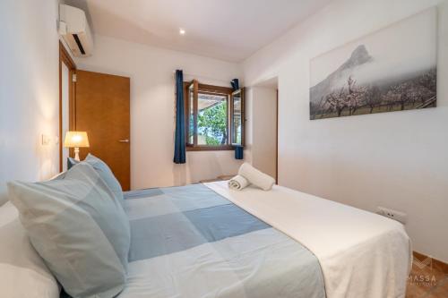a bedroom with a large white bed and a window at Finca Ca`n Jaumí, un paraíso con vista al mar y a la montaña in Artá