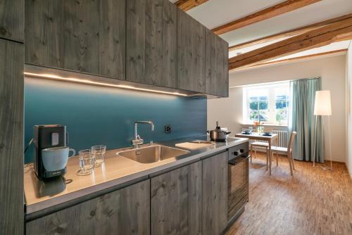 a kitchen with wooden cabinets and a sink and a table at Kloster Kappel in Kappel am Albis