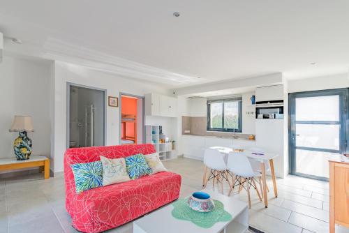 a living room with a red couch and a kitchen at Appartement charmant, Malaucène, 52 m², piscine partagée in Malaucène
