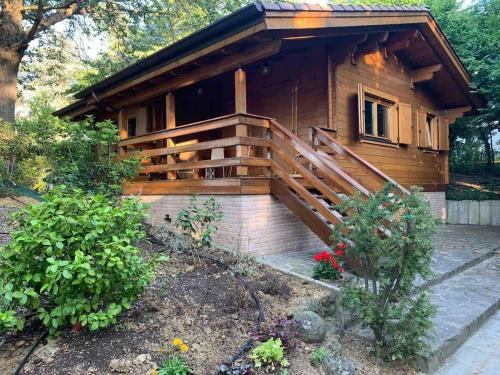 a log cabin with a porch and a wooden railing at Cozy Chalet in Castell'Arquato 90 m² with Private Pool in CastellʼArquato