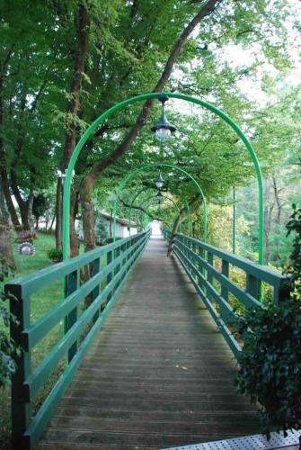 a bridge with a green canopy over a walkway at Cozy Chalet in Castell'Arquato 90 m² with Private Pool in CastellʼArquato