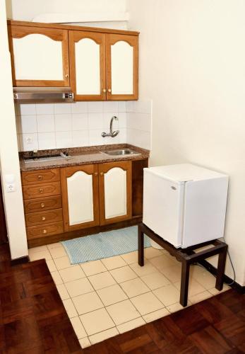 a kitchen with a sink and a refrigerator at Charming studio in Funchal, 30m², city view in Funchal