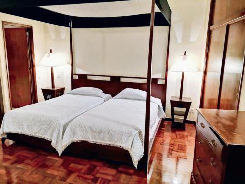 a bedroom with a canopy bed and two lamps at Charming studio in Funchal, 30m², city view in Funchal