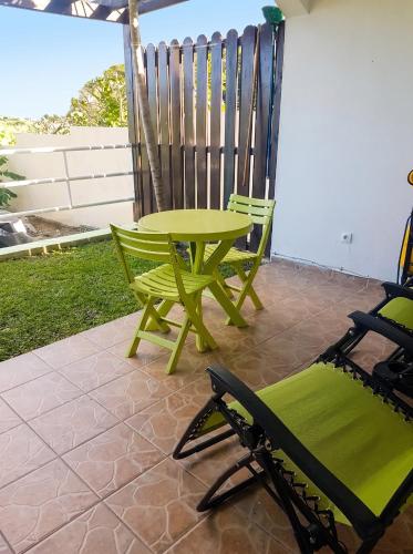 a green table and chairs on a patio at Charming Apartment in La Savane, 65 sqm with Terrace in Happy Bay