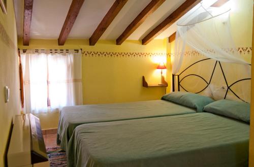 a bedroom with a green bed and a window at Comfortable Apartment in Robledillo de Gata with Balcony and View in Robledillo de Gata