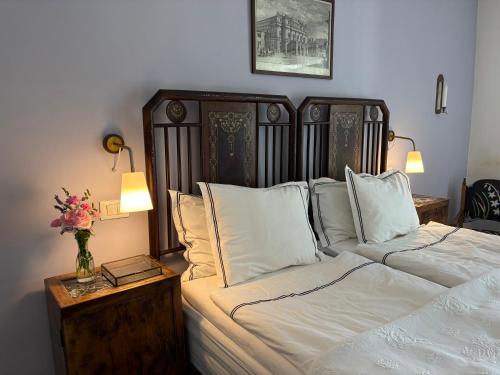 a bedroom with a bed with white sheets and a vase of flowers at Art & Breakfast in Ripabottoni