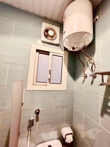 a bathroom with a toilet and a light on the wall at فندق جوهرة ذاخر رويال توصيل مجاني للحرم - Jewel Thakher Royal Hotel Free Shuttle to Haram in Mecca